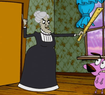 Screenshot from Courage the Cowardly Dog. An elderly schoolteacher wearing a black dress and holding a ruler glares down at Courage.